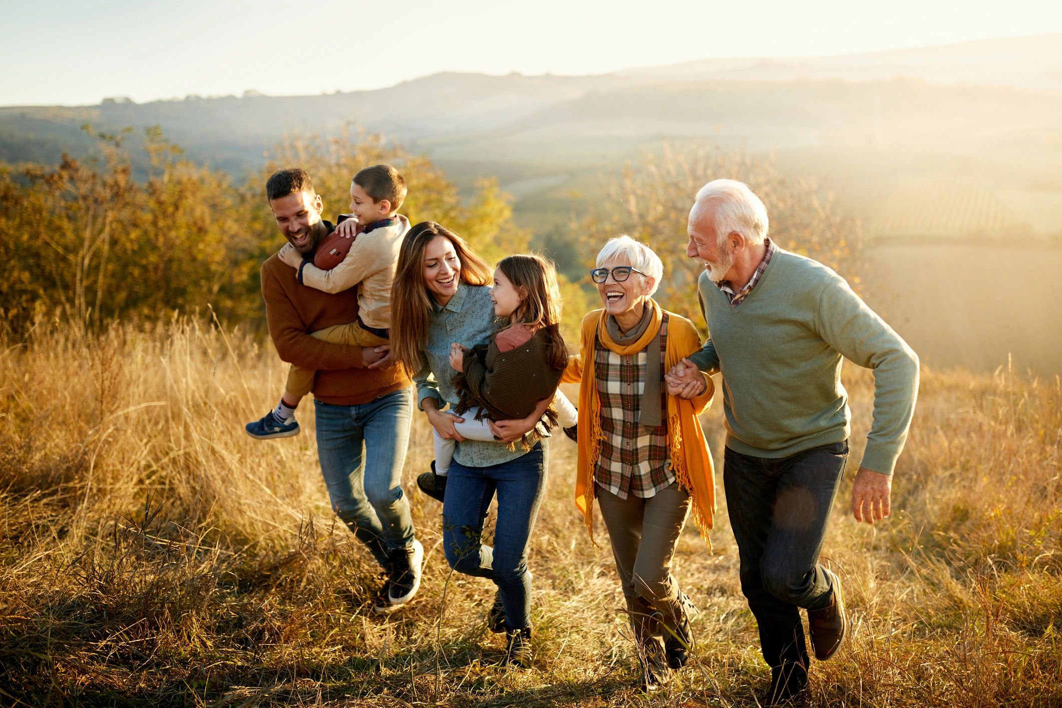 Multi-generation family running together on a hill